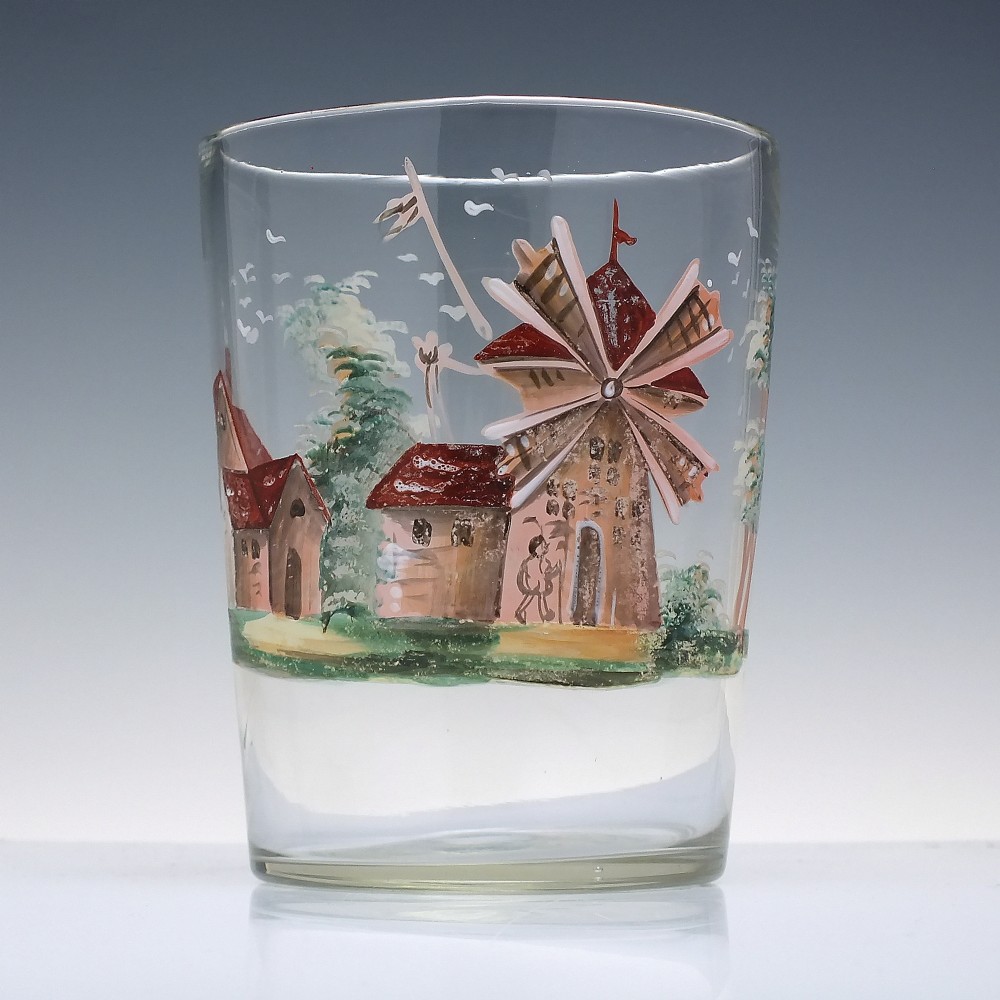 A clear glass tumbler featuring a hand-painted enamel illustration of a windmill and rural cottage.