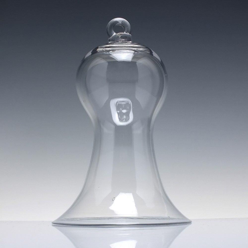 A clear hand-blown glass bell cloche dome featuring a looped glass top handle and a flared base rim.