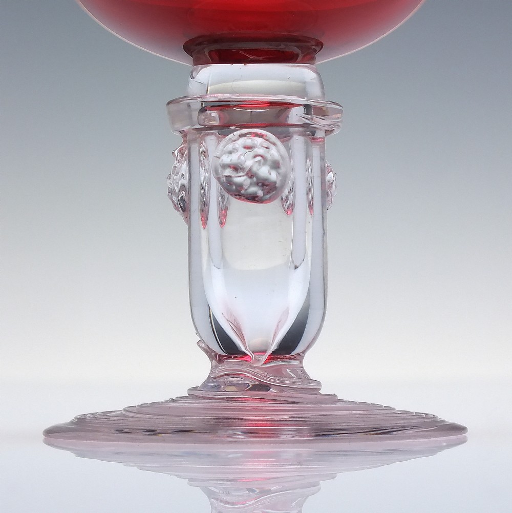 A pair of nineteenth-century Victorian wine glasses featuring deep cranberry red bowls and clear glass stems decorated with applied raspberry prunts. View III