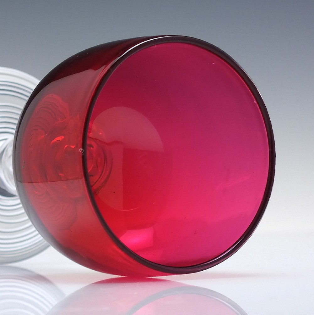 A pair of nineteenth-century Victorian wine glasses featuring deep cranberry red bowls and clear glass stems decorated with applied raspberry prunts. View V