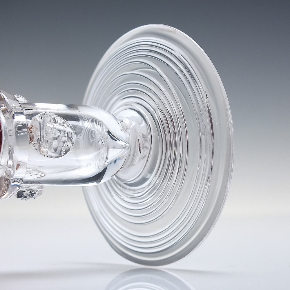 A pair of nineteenth-century Victorian wine glasses featuring deep cranberry red bowls and clear glass stems decorated with applied raspberry prunts. View VII