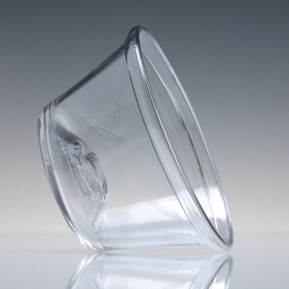 A small hand-blown clear glass Georgian patty pan dish with flared sides and a visible rough snapped pontil mark on the base. View IV