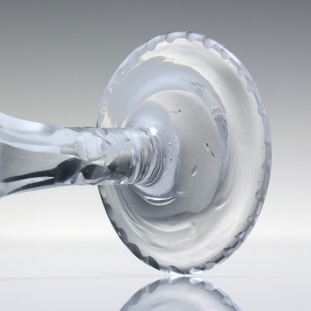 An antique clear cut lead crystal dram glass featuring diamond lattice cutting on the bowl, a faceted stem, and a flat circular base. View IV