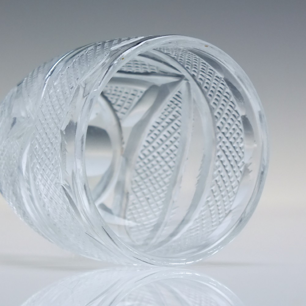 An antique clear cut lead crystal dram glass featuring diamond lattice cutting on the bowl, a faceted stem, and a flat circular base. View VII