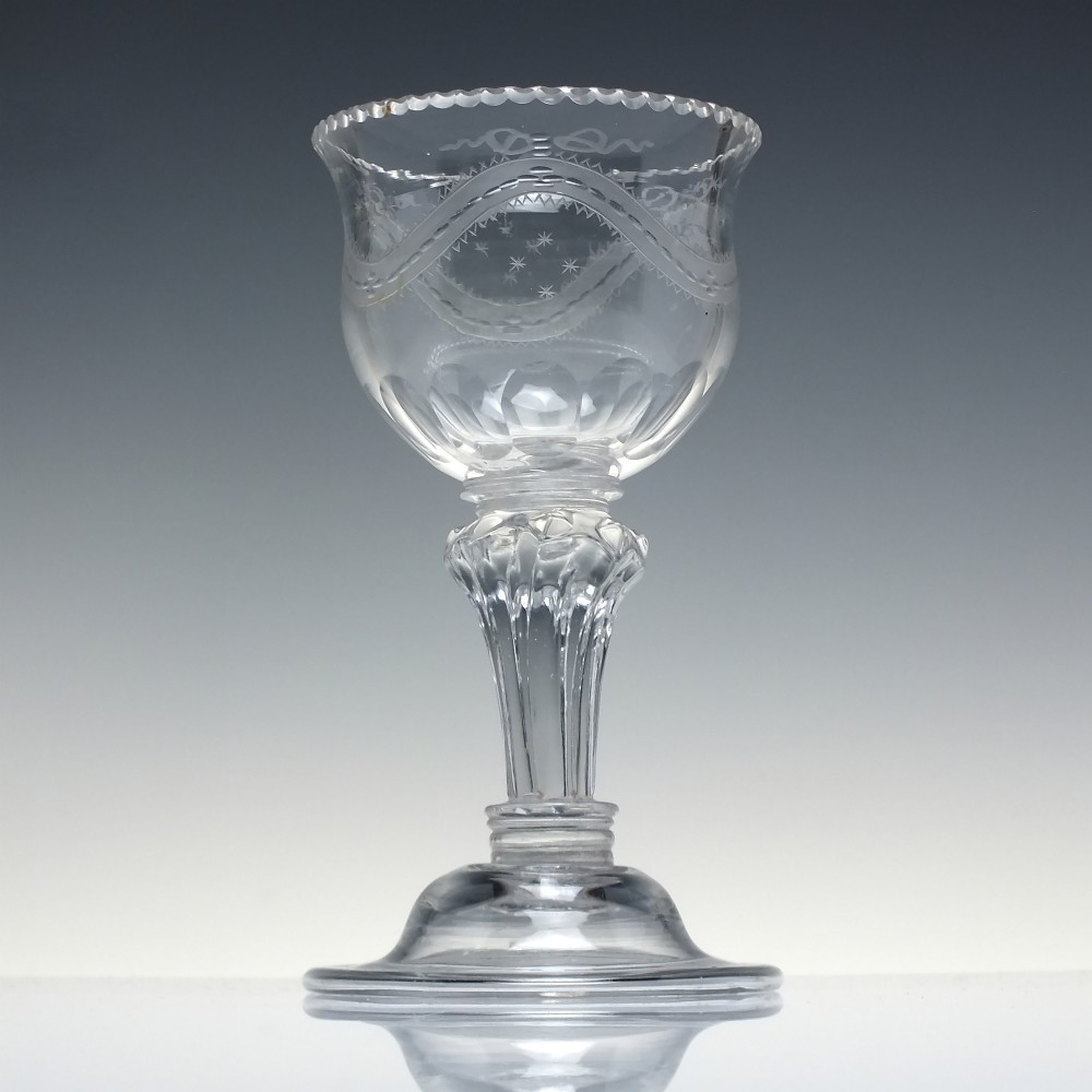 An 18th-century Georgian clear glass sweetmeat vessel featuring a wheel-engraved rim, faceted pedestal stem, and domed circular foot. View II