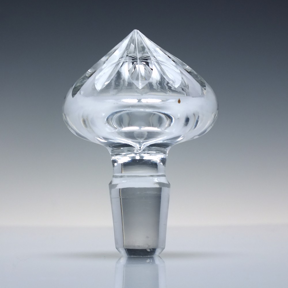 A clear cut crystal glass decanter with a geometric diamond cut body, smooth neck, and faceted glass stopper. View VI