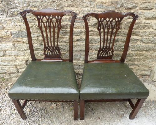 fig 1. A pair of Chippendale style Irish mahogany dining chairs with carved pierced splats and green leather upholstered seats.