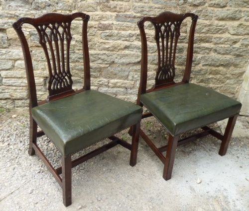 A pair of Chippendale style Irish mahogany dining chairs with carved pierced splats and green leather upholstered seats. View III