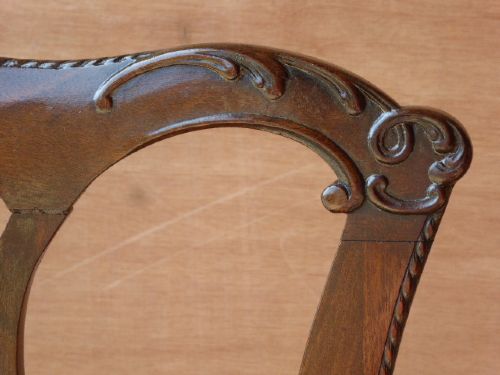 A pair of Chippendale style Irish mahogany dining chairs with carved pierced splats and green leather upholstered seats. View V