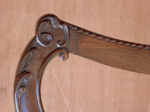 A pair of Chippendale style Irish mahogany dining chairs with carved pierced splats and green leather upholstered seats. View VI