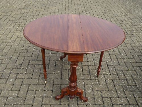 A Victorian solid walnut Sutherland table with folded drop leaves, turned baluster supports, and ceramic castors. View III