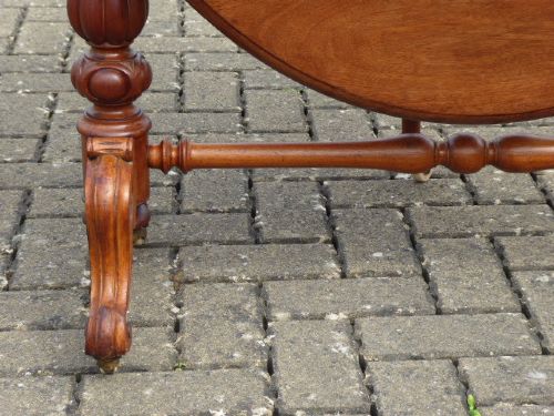 A Victorian solid walnut Sutherland table with folded drop leaves, turned baluster supports, and ceramic castors. View V