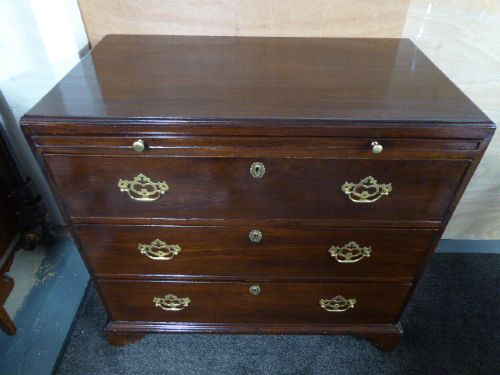 A Georgian mahogany chest of drawers featuring three long drawers, brass handles, a brushing slide, and bracket feet. View II