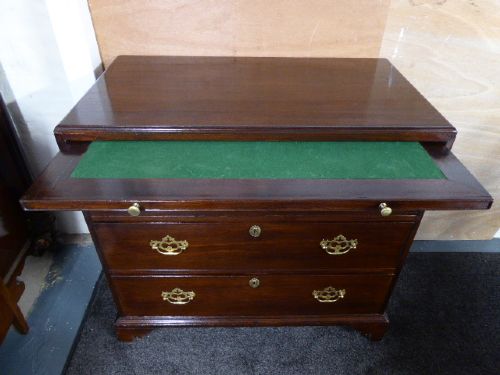 A Georgian mahogany chest of drawers featuring three long drawers, brass handles, a brushing slide, and bracket feet. View III