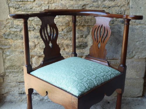 A walnut Queen Anne corner chair with a curved horseshoe armrest, two pierced splats, a green patterned upholstered drop-in seat, and a front cabriole leg. View II