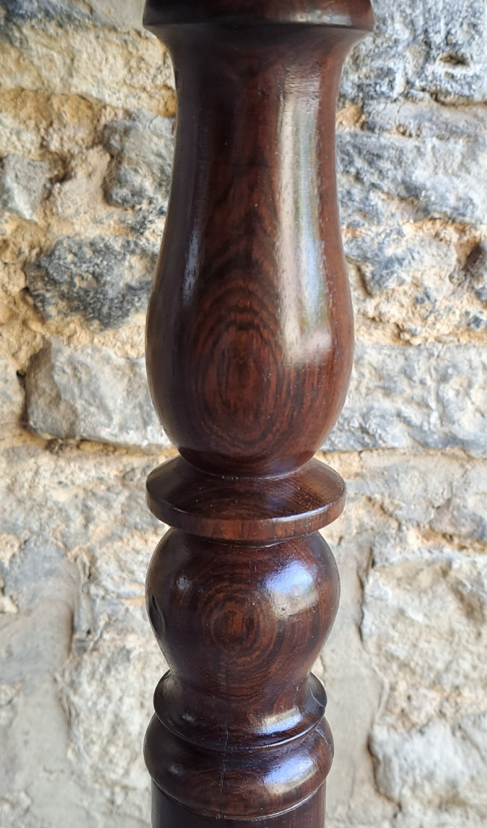 An antique round rosewood wine table featuring a turned pedestal column and a tripod base. View V