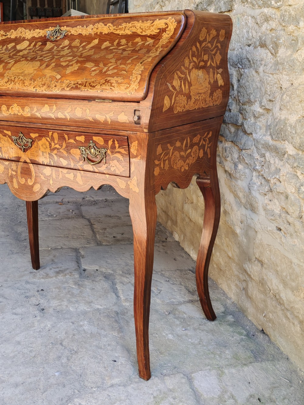 An antique Dutch mahogany writing bureau with intricate floral wood marquetry, a sloped fall front, a single drawer, and cabriole legs. View IV