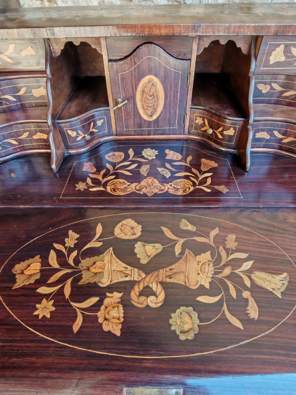An antique Dutch mahogany writing bureau with intricate floral wood marquetry, a sloped fall front, a single drawer, and cabriole legs. View XI