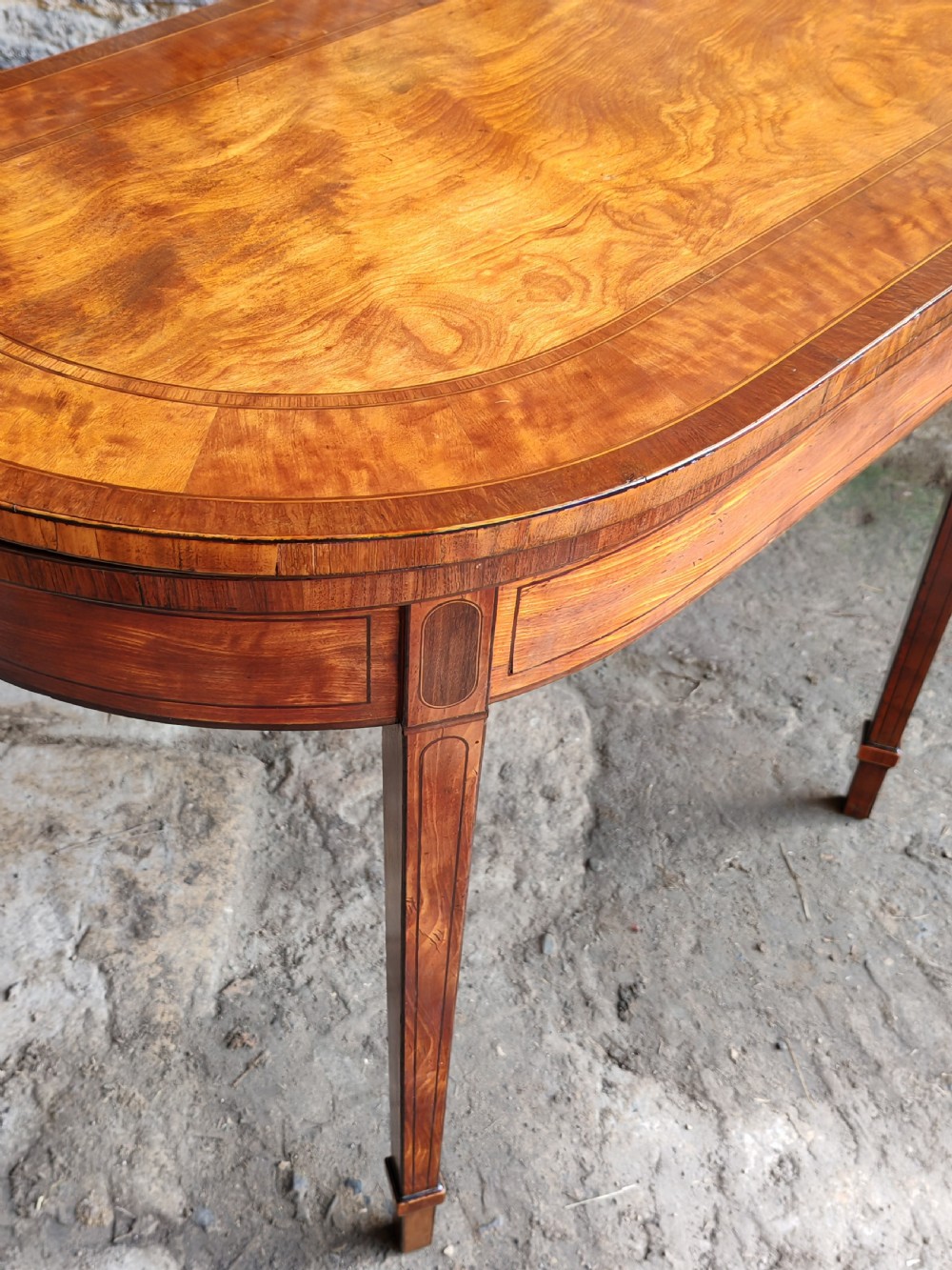 A late eighteenth-century Georgian satinwood demi-lune card table featuring inlaid crossbanding and four square tapered legs. View VI