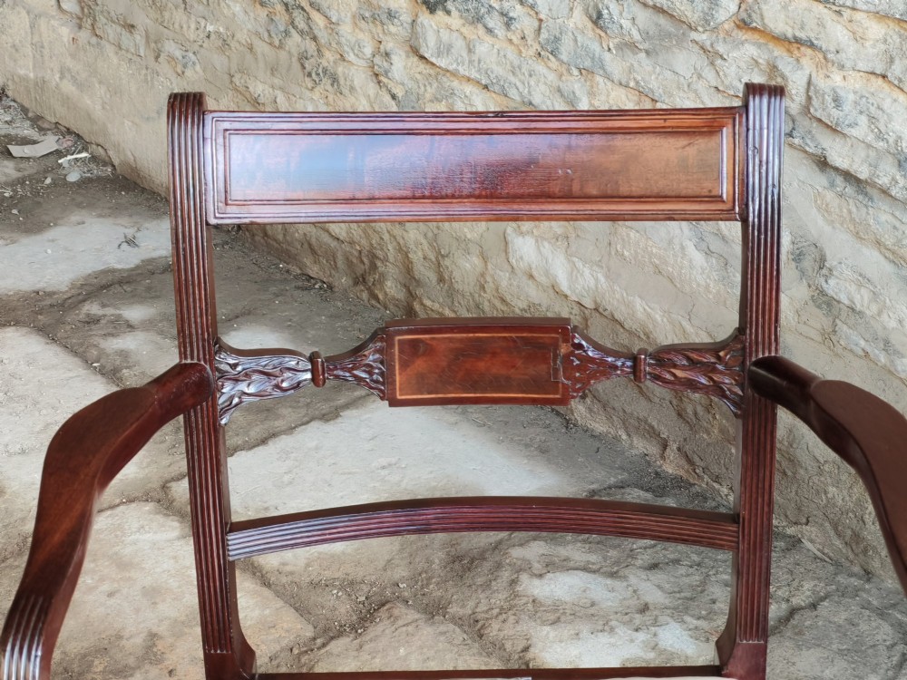 A Georgian mahogany carver armchair featuring reeded arms, a central carved splat, an upholstered seat, turned front legs, and an X-frame stretcher. View III