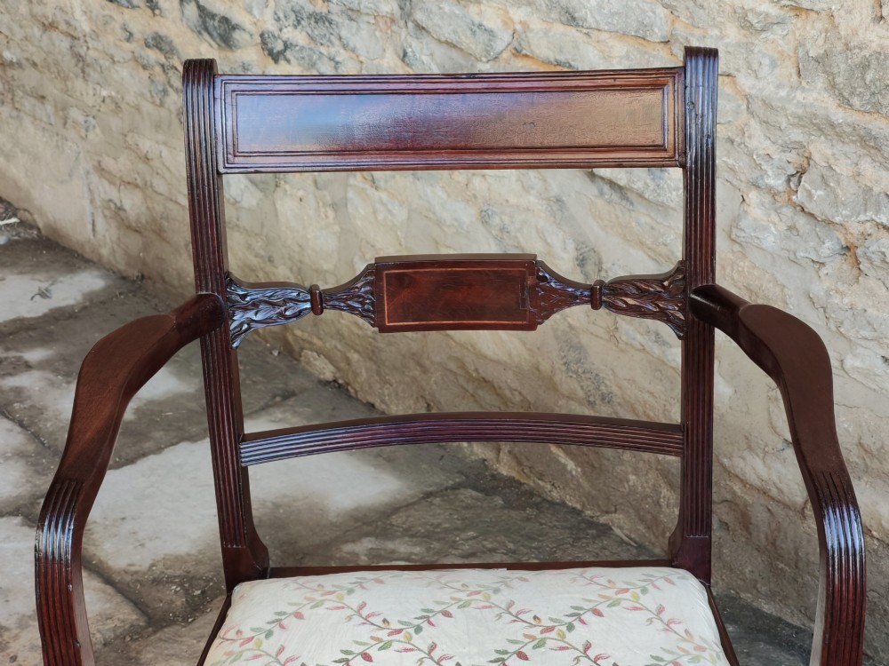 A Georgian mahogany carver armchair featuring reeded arms, a central carved splat, an upholstered seat, turned front legs, and an X-frame stretcher. View IV