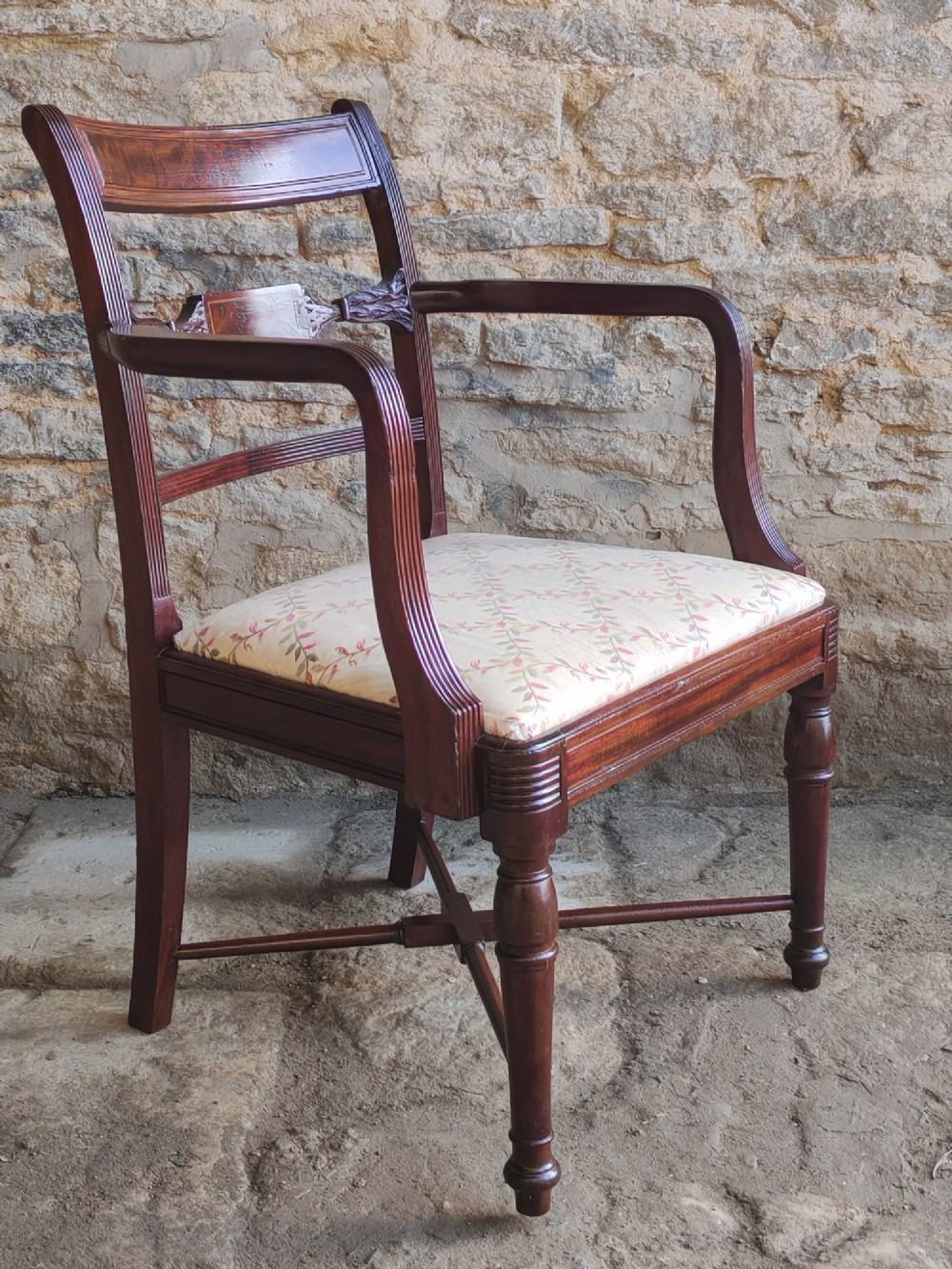 A Georgian mahogany carver armchair featuring reeded arms, a central carved splat, an upholstered seat, turned front legs, and an X-frame stretcher. View VII
