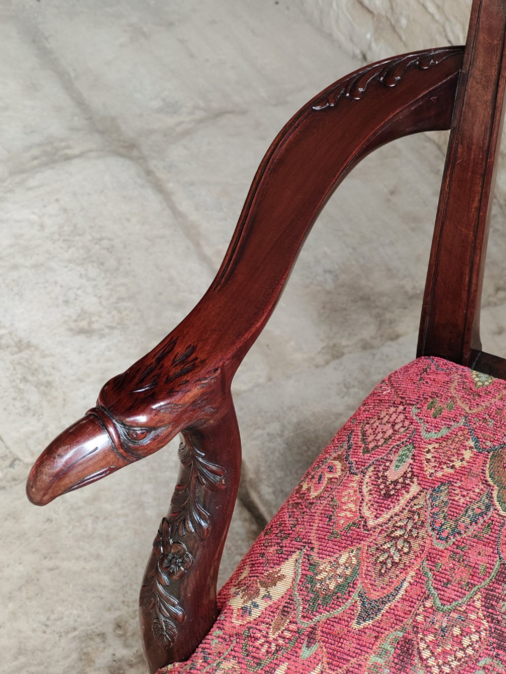 An antique dark mahogany carver armchair with a carved pierced splat back, eagle head armrests, patterned red upholstered seat, and square legs with an H-stretcher. View VII