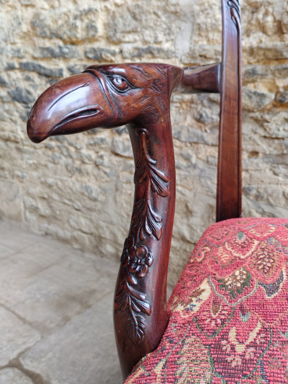 An antique dark mahogany carver armchair with a carved pierced splat back, eagle head armrests, patterned red upholstered seat, and square legs with an H-stretcher. View VIII