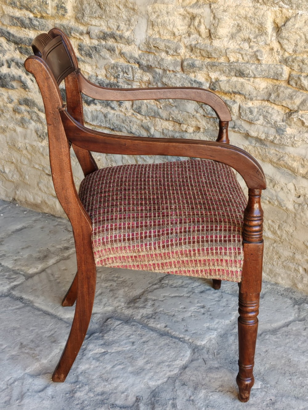 A Regency dark mahogany carver chair featuring a carved rope twist back rail, curved armrests, turned front legs, and a patterned woven upholstery seat. View IV