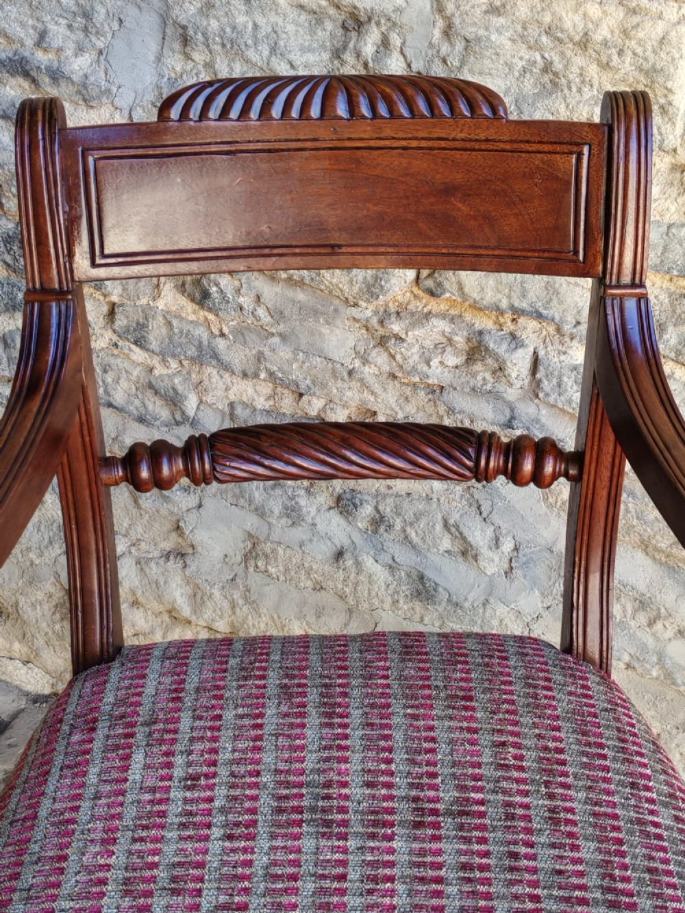A Regency dark mahogany carver chair featuring a carved rope twist back rail, curved armrests, turned front legs, and a patterned woven upholstery seat. View V