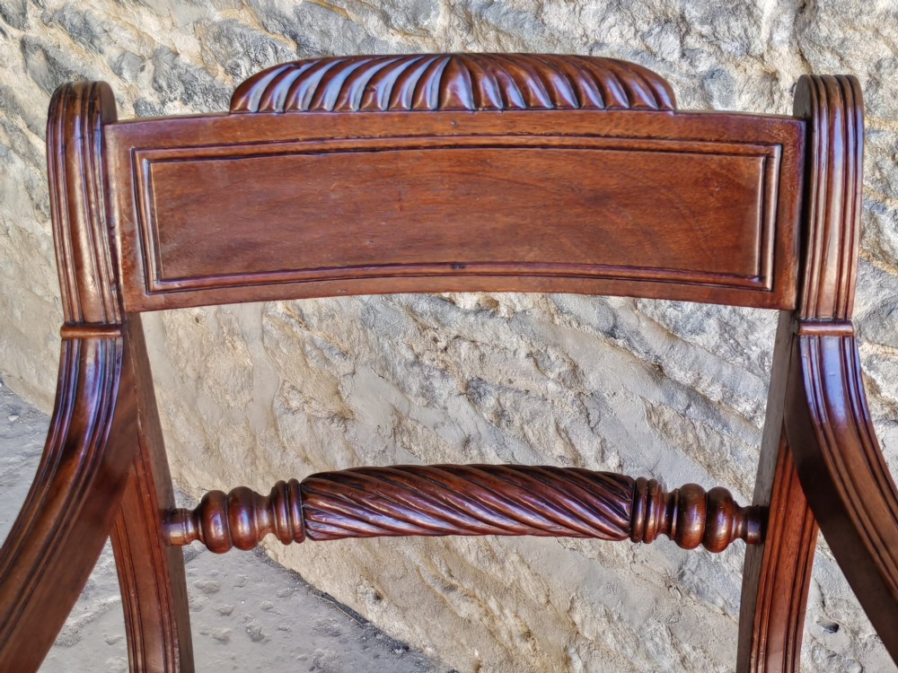 A Regency dark mahogany carver chair featuring a carved rope twist back rail, curved armrests, turned front legs, and a patterned woven upholstery seat. View VI