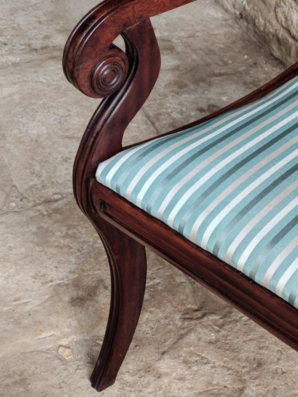 A pair of Regency mahogany carver dining chairs featuring rope-twist back rails, reeded scrolled arms, sabre front legs, and light blue striped upholstered seats. View VII