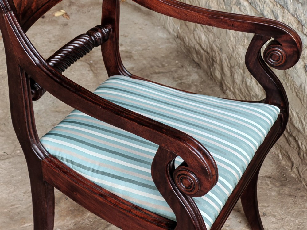 A pair of Regency mahogany carver dining chairs featuring rope-twist back rails, reeded scrolled arms, sabre front legs, and light blue striped upholstered seats. View VIII