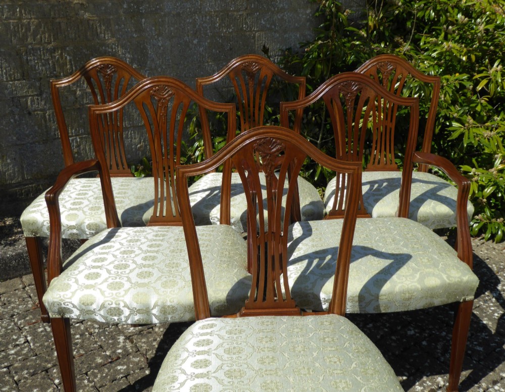 A set of six mahogany dining chairs featuring carved pierced back splats, tapered legs, and pale green patterned upholstery. View IV