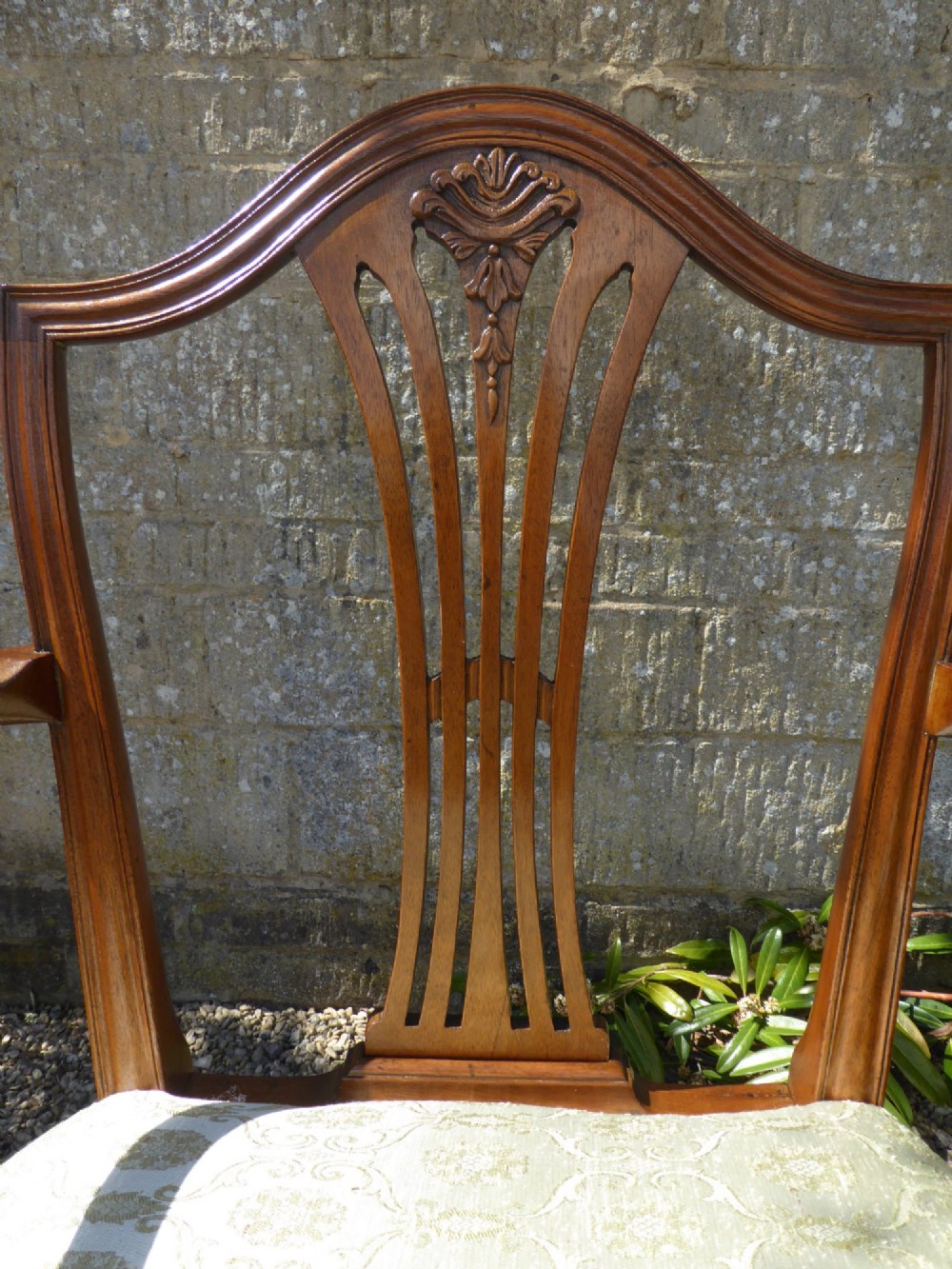A set of six mahogany dining chairs featuring carved pierced back splats, tapered legs, and pale green patterned upholstery. View V