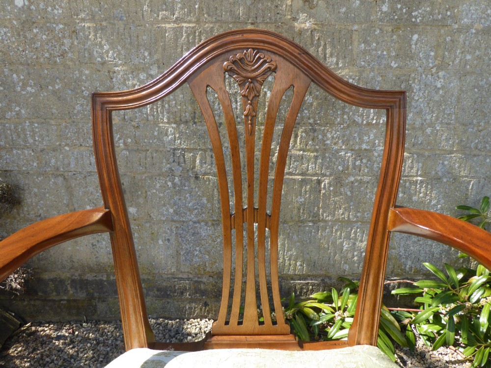 A set of six mahogany dining chairs featuring carved pierced back splats, tapered legs, and pale green patterned upholstery. View VI