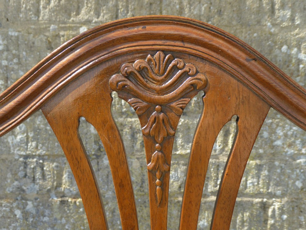 A set of six mahogany dining chairs featuring carved pierced back splats, tapered legs, and pale green patterned upholstery. View VII