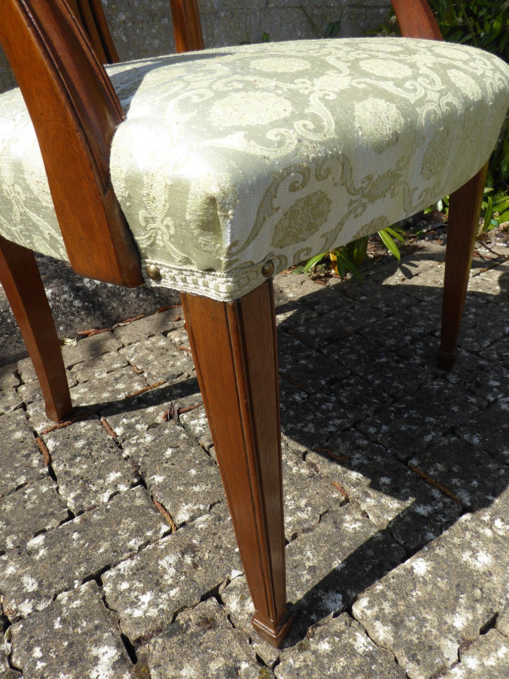 A set of six mahogany dining chairs featuring carved pierced back splats, tapered legs, and pale green patterned upholstery. View VIII