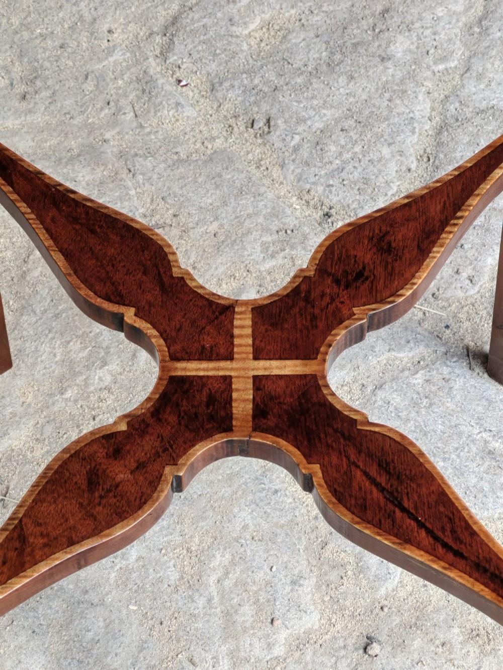 An octagonal late Victorian wood bijouterie table with marquetry swags, a glazed top displaying a pink fabric lining, tapering square legs, and a shaped cross-stretcher. View X