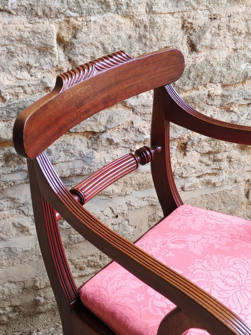 A Regency mahogany carver chair featuring scrolled arms, rope twist carving on the back rail, and a pink upholstered seat. View IV