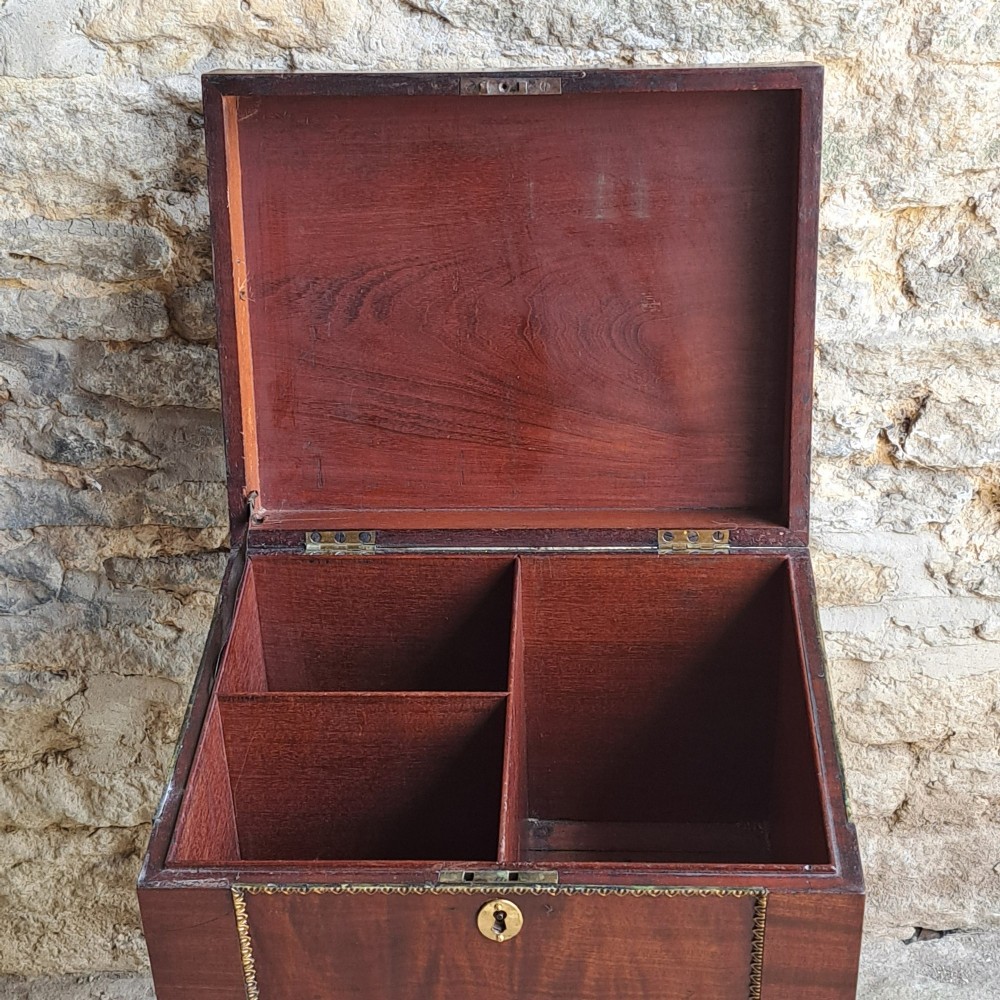 A tall Regency mahogany cellaret with a hinged lid, decorative ormolu beaded borders, a brass keyhole, and turned legs with brass castors. View VII