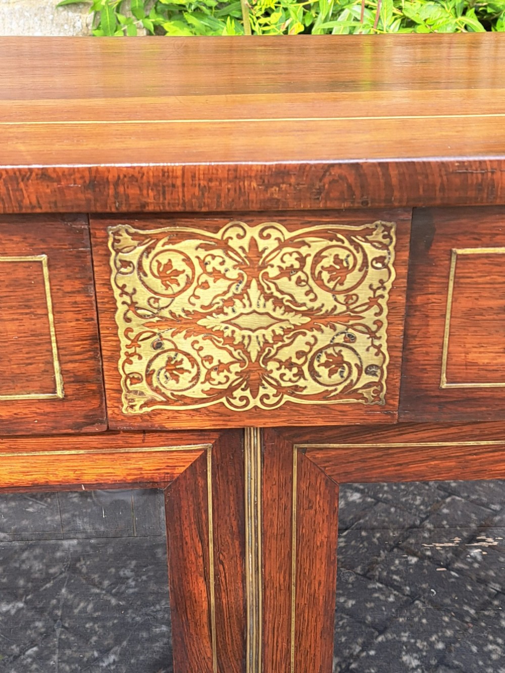 An 1830s rosewood low bookcase featuring twin glazed doors, scroll feet, and foliate brass inlay across the frieze and pilasters. View VII