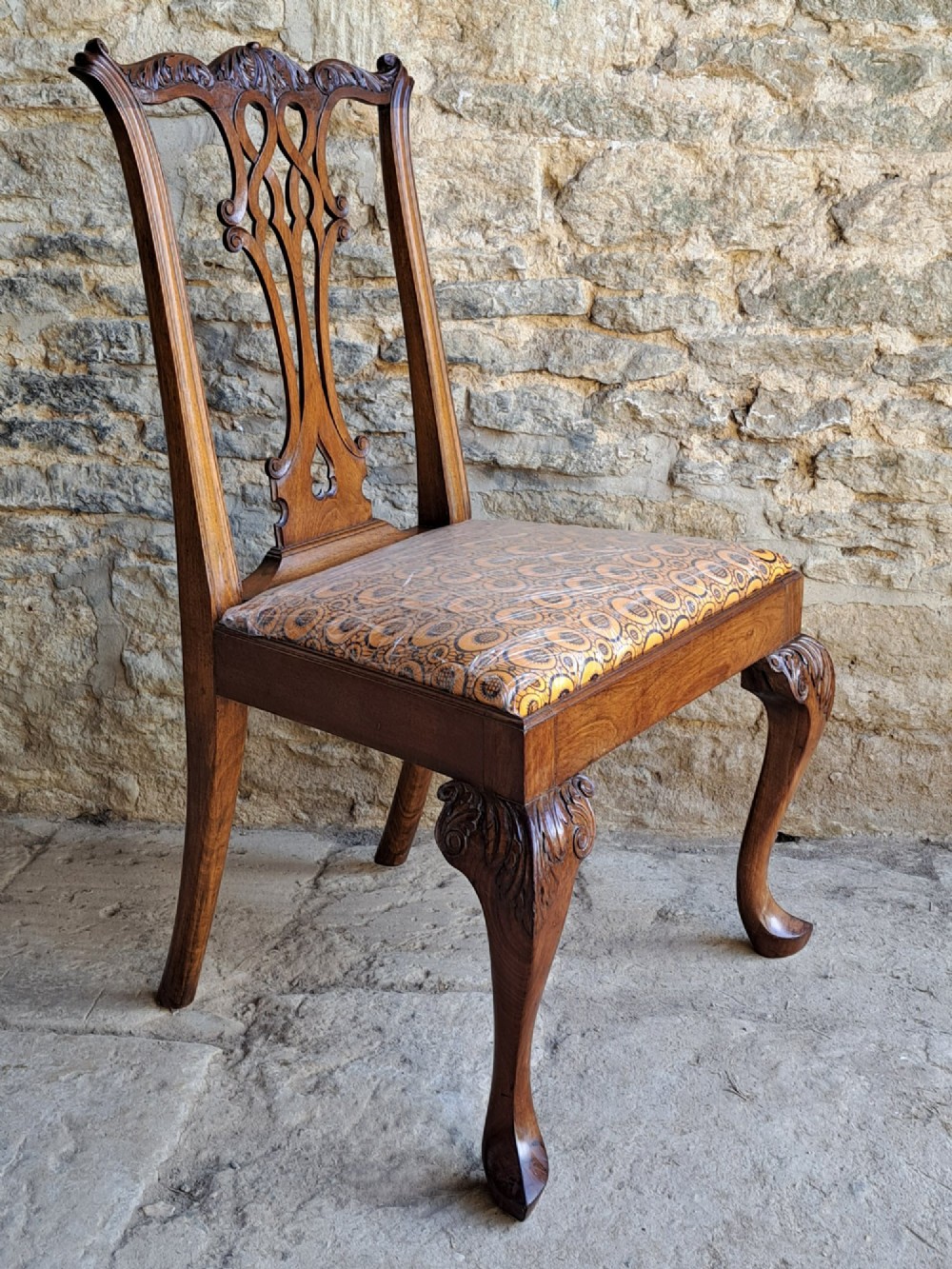 A 19th-century walnut side chair featuring an intricately carved pierced back splat, cabriole legs with carved knees, and a patterned upholstered seat. View II