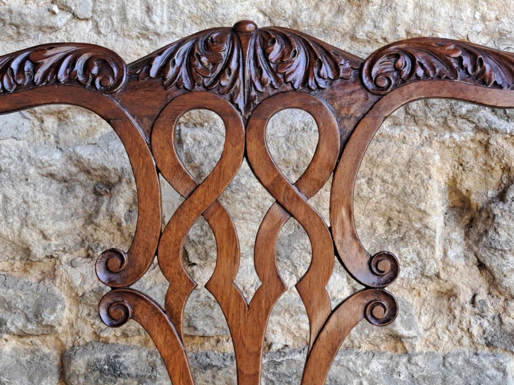 A 19th-century walnut side chair featuring an intricately carved pierced back splat, cabriole legs with carved knees, and a patterned upholstered seat. View VI
