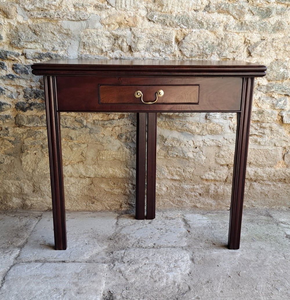 An 18th-century Georgian Cuban mahogany tea table featuring a rectangular foldover top, a single drawer with a brass handle, and straight moulded legs. View II