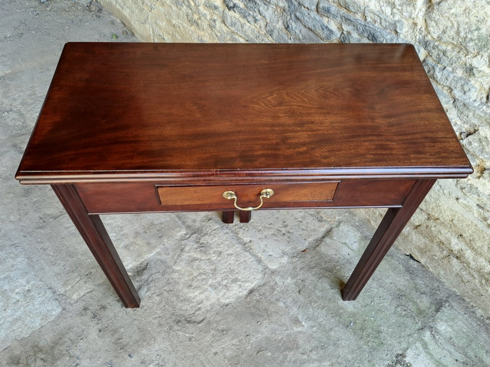 An 18th-century Georgian Cuban mahogany tea table featuring a rectangular foldover top, a single drawer with a brass handle, and straight moulded legs. View III