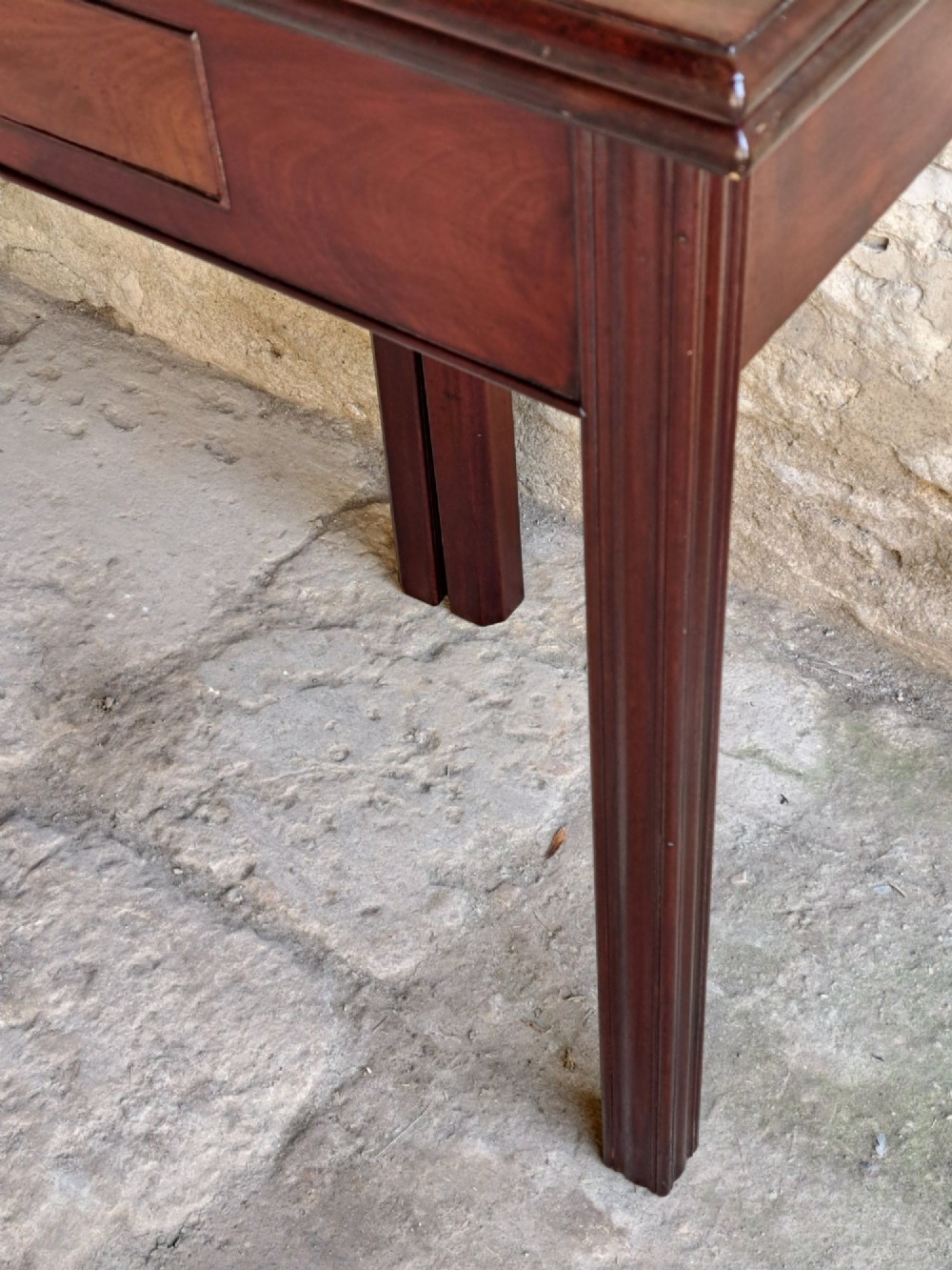 An 18th-century Georgian Cuban mahogany tea table featuring a rectangular foldover top, a single drawer with a brass handle, and straight moulded legs. View VII
