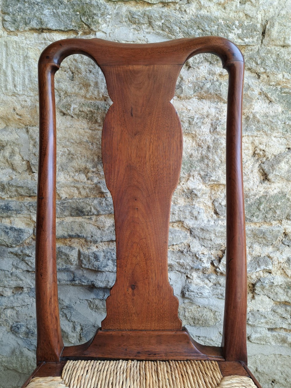 A Queen Anne walnut side chair featuring a solid vase-shaped back splat, a woven rush seat, cabriole front legs with pad feet, and turned stretchers. View V