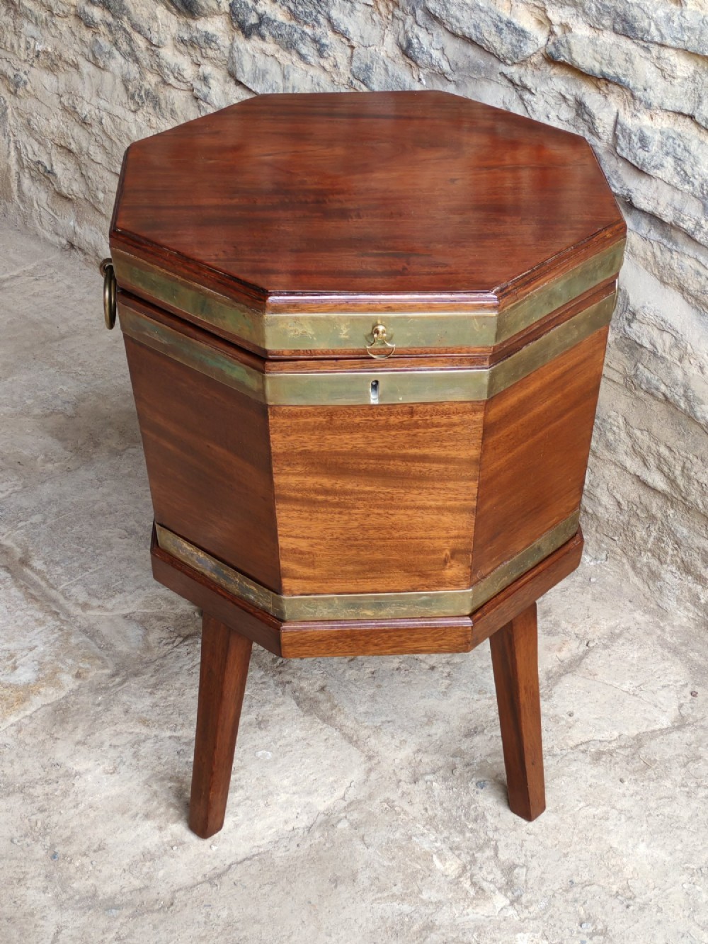 An 18th-century octagonal mahogany wine cooler with brass bindings, brass handles, and four tapered square legs. View II