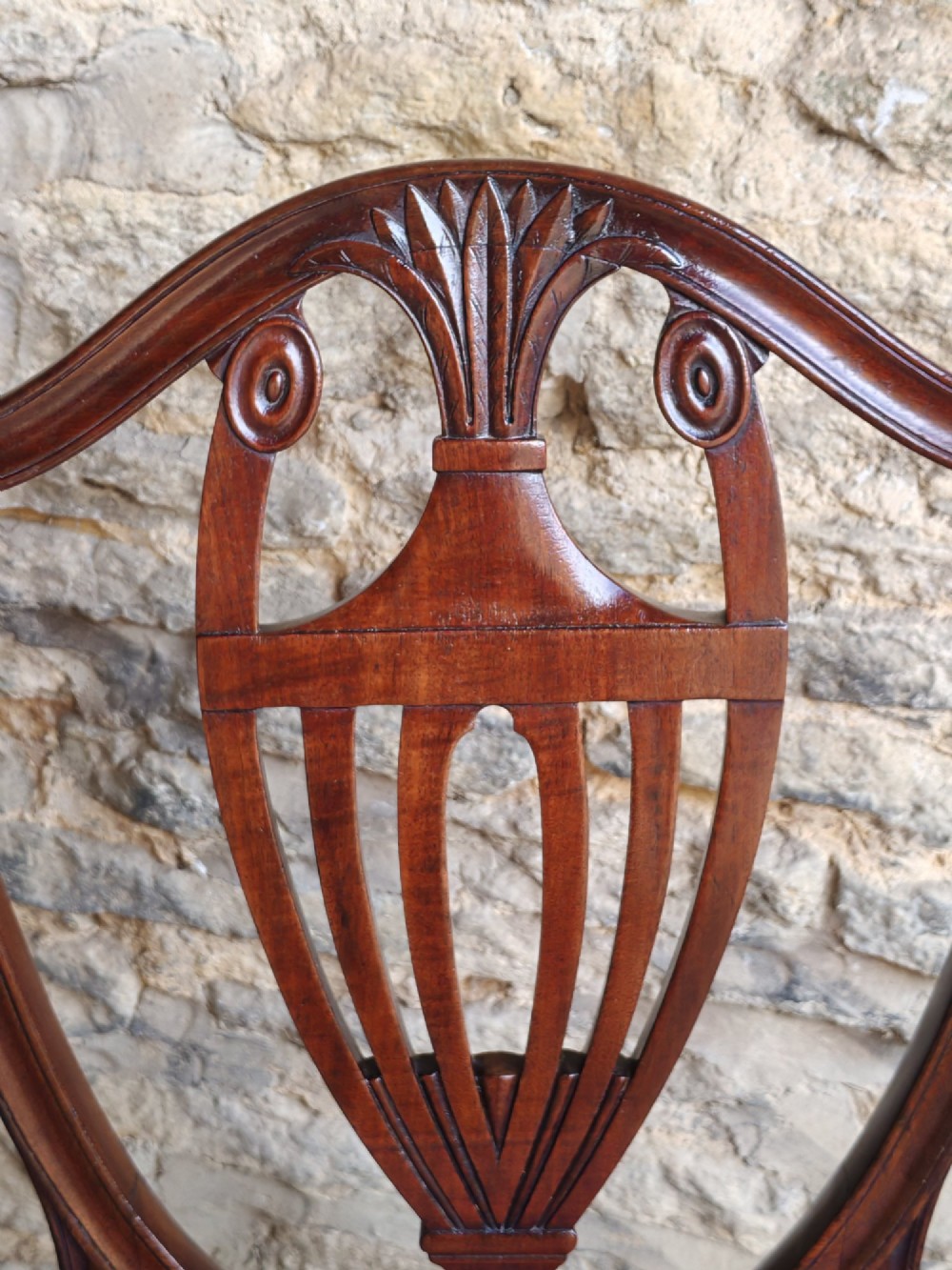 A set of six mahogany Hepplewhite dining chairs featuring carved shield backs with urn motifs and striped fabric upholstery. View V